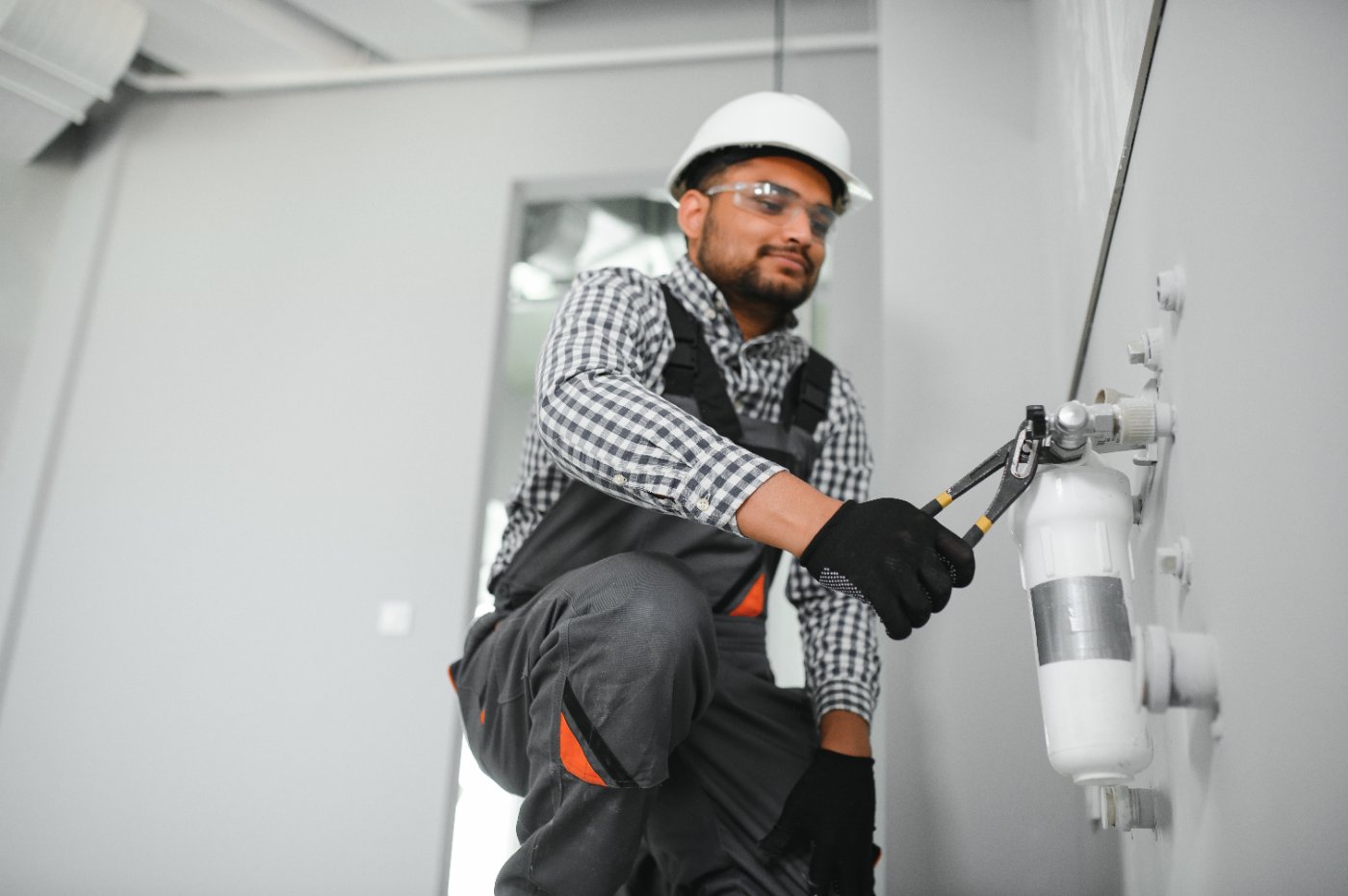 Plumber installing a whole-home water filtration cartridge housing